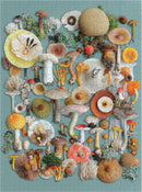 A colorful jigsaw puzzle titled 'Foraged' by Galison, featuring various mushrooms and fungi arranged aesthetically on a green background. The puzzle pieces show a rich diversity of shapes and colors, including yellow, orange, and white mushrooms, as well as hints of greenery and textures.