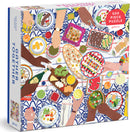 Gather Together jigsaw puzzle featuring an overhead view of a beautifully set table filled with diverse dishes, hands reaching in to share food, and vibrant colors. This 500-piece puzzle by Galison captures the essence of community and feasting together, making it a perfect gift for puzzle lovers and those who enjoy a fun, engaging challenge.