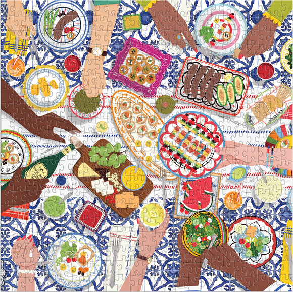 A colorful jigsaw puzzle titled 'Gather Together' by Galison, featuring an overhead view of a vibrant dining scene. Hands are reaching for various dishes filled with food, including salads, appetizers, and drinks, set against a patterned tablecloth. The puzzle illustrates a communal meal, emphasizing togetherness and the joy of sharing food.