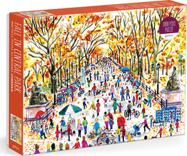 Michael Storrings 'Fall in Central Park' jigsaw puzzle by Galison featuring a vibrant autumn scene with crowds enjoying the park, colorful trees, and various outdoor activities. The illustration captures the essence of fall with warm colors and lively characters.