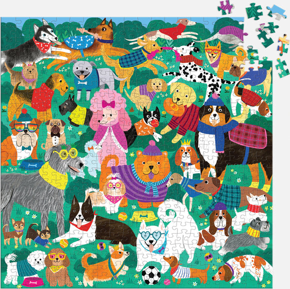 A vibrant 500-piece jigsaw puzzle called 'Doggone Days' by Mudpuppy, featuring an array of playful dogs in colorful sweaters and accessories, set in a cheerful park scene with flowers and greenery. The puzzle showcases various dog breeds including poodles, bulldogs, and huskies, interacting in a lively and whimsical manner.