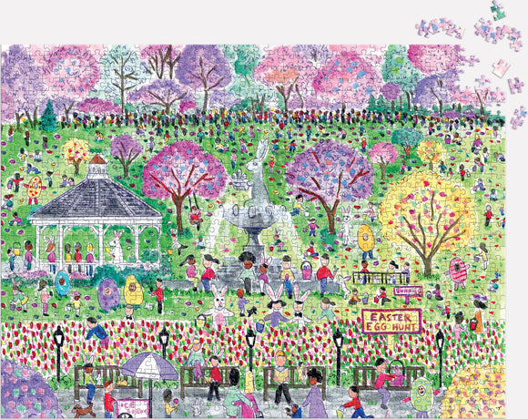 A colorful jigsaw puzzle titled 'Michael Storrings Easter Egg Hunt' featuring a vibrant park scene filled with people participating in an Easter egg hunt. The image includes blossoming trees, a gazebo, and various Easter-themed decorations, creating a cheerful atmosphere. Puzzle pieces are scattered nearby, hinting at the fun to come.