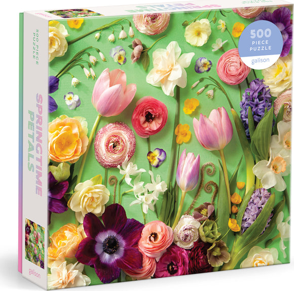 Springtime Petals 500-piece jigsaw puzzle by Galison featuring a vibrant array of flowers including tulips, ranunculus, and daffodils on a green background. The packaging showcases the colorful floral design, highlighting the beauty of spring.