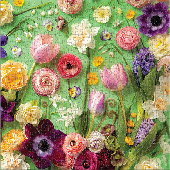A vibrant jigsaw puzzle featuring an arrangement of colorful spring flowers, including tulips, roses, and hyacinths, set against a lush green background. This 500-piece puzzle showcases intricate floral designs and vivid colors, inviting puzzle enthusiasts to assemble a beautiful springtime scene.