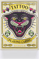 Tattoo Playing Cards by Chronicle Books featuring a vibrant and artistic design of a snarling black panther with gold and colorful accents. The packaging showcases playful illustrations including dice and decorative elements, combining classic playing card aesthetics with a tattoo-inspired theme.