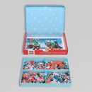 The LEGO Puzzle Christmas Train jigsaw puzzle features a vibrant winter scene with a festive train and colorful LEGO pieces, neatly organized in compartments. The box is decorated with a blue snowflake pattern, adding to the holiday cheer.