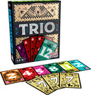 The game 'Trio' by Happy Camper features a colorful box design with intricate patterns and illustrations. The game cards include numbers and vibrant colors, displayed spread out below the box, highlighting gameplay elements. Suitable for 3 to 6 players aged 8 and above.