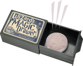 Wizard's Magic Drawer by House of Marbles, featuring a decorative box with the title on the lid. The interior displays a round, coin-like object and mechanisms suggesting disappearing and reappearing magic tricks.
