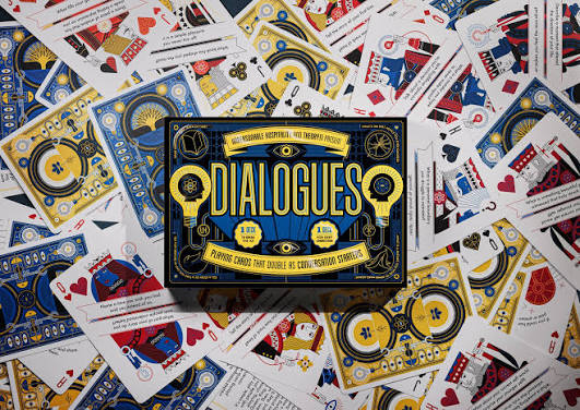 Dialogues card game box on top of cards from the game