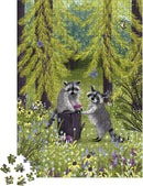 A colorful jigsaw puzzle featuring two playful raccoons amidst lush green trees and vibrant wildflowers. One raccoon is perched on a stump, while the other holds a berry. The puzzle pieces scatter around the base, showcasing the vivid forest scene.