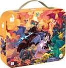 A vibrant jigsaw puzzle by Janod featuring fiery dragons in a volcanic landscape. The colorful box shows dynamic dragons in various colors and poses, surrounded by rocky mountains and treasures, perfect for children aged 5 and up.