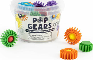 A clear container filled with colorful plastic gears in various shapes, featuring a warning label advising of small parts. Visible gears include green, yellow, blue, orange, purple, and red. The product enables children over 3 years to create endless shapes and designs, promoting creativity and fine motor skills.