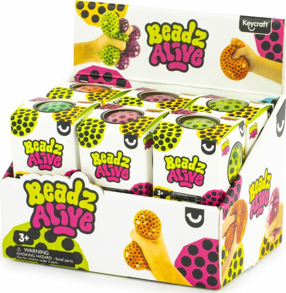A colorful display of Beadz Alive Balls by Keycraft. The image features various colors of the sensory balls, showcasing their unique textures and designs. A hand is holding two balls, emphasizing their tactile nature. The packaging is vibrant with bold colors and patterns.