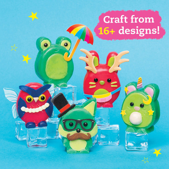 A colorful display of five easy-to-carve wax animals in various designs, including a green frog with a yellow umbrella, a red animal with antlers, a blue owl with a white smile, a green fox wearing glasses and a mustache, and a cute green creature with a horn. The figures are arranged on clear ice cubes against a light blue background with playful star accents.