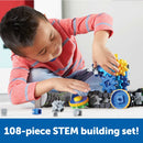 A young child is engaged in building with the Gears! Gears! Gears! Treadmobile DIY kit from Learning Resources. The child is focused on connecting colorful gears and components, showing creativity and engagement in hands-on STEM learning. Surrounding them are various pieces from the 108-piece set, promoting fine motor skills and imaginative play.