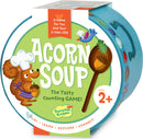 Acorn Soup game by Peaceable Kingdom featuring a cheerful squirrel chef holding an acorn. The packaging is vibrant with playful illustrations including a bird and various colorful ingredients. It promotes counting and is suitable for children aged 2 and up, emphasizing play, learning, exploration, and connection.