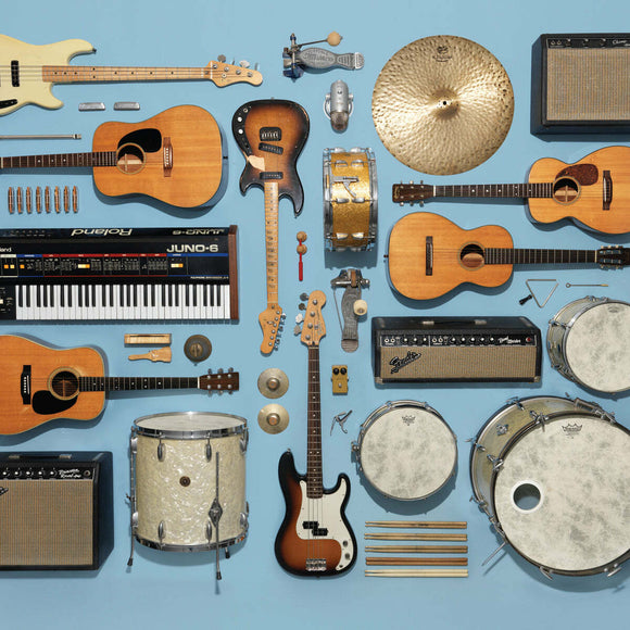 An artistic arrangement of various musical instruments, including guitars, drums, cymbals, amplifiers, and a keyboard, showcasing an array of textures and colors against a soft blue background. This jigsaw puzzle offers a unique and engaging challenge for music lovers and puzzle enthusiasts alike.