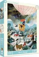 A vibrant jigsaw puzzle box titled 'On a Voyage' by New York Puzzle Company, featuring a whimsical illustration of a girl in a hot air balloon amidst a picturesque landscape with mountains, houses, and trees. The puzzle contains 1000 pieces, inviting adventurers to piece together this enchanting scene.
