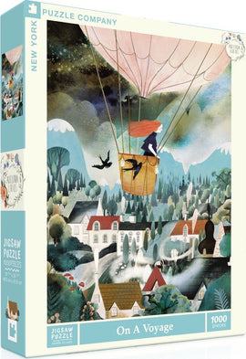 A vibrant jigsaw puzzle box titled 'On a Voyage' by New York Puzzle Company, featuring a whimsical illustration of a girl in a hot air balloon amidst a picturesque landscape with mountains, houses, and trees. The puzzle contains 1000 pieces, inviting adventurers to piece together this enchanting scene.