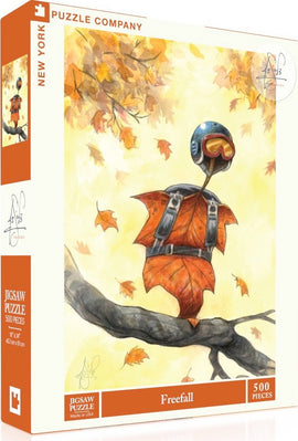 The Freefall jigsaw puzzle by New York Puzzle Company features a whimsical illustration of a character made of leaves, dressed in a blue helmet and orange gear. The character is perched on a branch among autumn leaves, showcasing vibrant colors that evoke a sense of adventure in nature. The puzzle contains 500 pieces and is designed for ages 3 and up.