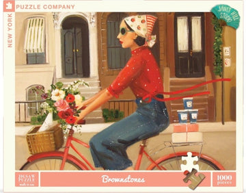 A colorful jigsaw puzzle featuring a woman in a red polka-dot shirt riding a vintage bicycle adorned with a bouquet of flowers. She has a scarf tied around her head and sunglasses on. In the background, there are brownstone buildings with a warm and inviting atmosphere. The puzzle is by New York Puzzle Company and comprises 1000 pieces.