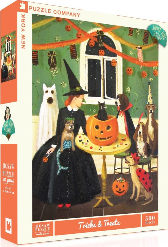 Artwork of Jigsaw Puzzle 'Tricks & Treats' featuring a woman in a witch costume surrounded by various dogs and a pumpkin centerpiece, with Halloween decorations adorning a room. The puzzle consists of 500 pieces, designed by Janet Hill Studio.