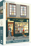 The Book Exchange jigsaw puzzle by New York Puzzle Company with 1000 pieces, depicting a quaint bookstore scene featuring a storefront adorned with festive decorations, two characters interacting, and a cat nearby.