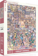 A colorful box showcasing the Vibrant Varanasi jigsaw puzzle by New York Puzzle Company. The puzzle features a bustling scene of people in traditional attire around the iconic temples and ghats of Varanasi, India, captured in intricate detail. It contains 1000 pieces, perfect for puzzle enthusiasts who appreciate vibrant artistry and cultural richness.