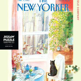 A visually captivating 1000-piece jigsaw puzzle titled 'Cat's Eye View' by New York Puzzle Company. The image depicts a cozy indoor scene with a black cat sitting on a chair, gazing out a window at a vibrant city skyline. The table is set with blue teapots, a fruit, and papers, all framed by lush greenery, inviting a sense of warmth and tranquility. This artwork, originally a New Yorker cover by Sempe, is perfect for puzzle enthusiasts and city lovers alike.