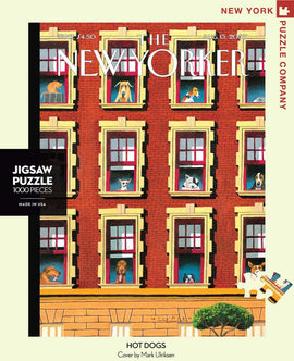 The Hot Dogs jigsaw puzzle by New York Puzzle Company features an illustration by Mark Ulriksen showing various dogs looking out of colorful apartment windows. The puzzle consists of 1000 pieces and celebrates the charming scenes of canine life in a vibrant urban setting.