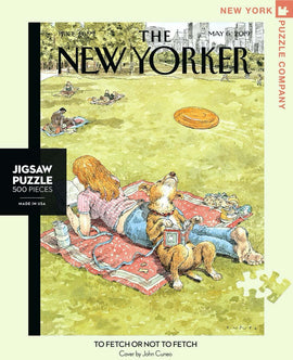 A jigsaw puzzle titled 'To Fetch or Not To Fetch' by New York Puzzle Company, featuring an illustrated scene from The New Yorker. The image shows a girl relaxing on a picnic blanket with her dog in a sunny park, capturing a playful moment with a frisbee in the background. The puzzle contains 500 pieces and is proudly made in the USA.