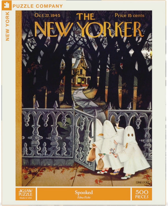 The 'Spooked' jigsaw puzzle by New York Puzzle Company features a vintage illustration from the October 27, 1945 issue of The New Yorker. The artwork depicts three ghostly children in white sheets with bags, approaching a wrought iron gate leading to a spooky, leaf-strewn path that leads to an inviting haunted house, framed by dark, tall trees. The puzzle contains 500 pieces and highlights playful Halloween themes, making it perfect for family fun or seasonal decor.