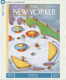 A 500-piece jigsaw puzzle titled 'Pinball Piste' featuring a whimsical illustration by John O'Brien from The New Yorker magazine, depicting a snowy landscape with skiers and colorful pinball-like structures. The puzzle artwork showcases vibrant colors and playful scenes from a ski resort.