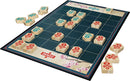 Zensu game by Cheatwell Games displayed on a vibrant board. The board features a grid with intricately designed wooden pieces in various colors, illustrating the game's strategic layout. Cherry blossom motifs enhance the aesthetic. A few pieces are set aside, indicating an engaging gameplay experience.