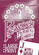 A close-up view of a deck of large print playing cards by Outset Media. The box features an elegant peacock design with intricate details and the text 'Large Print'. A visible card shows the Jack of diamonds.