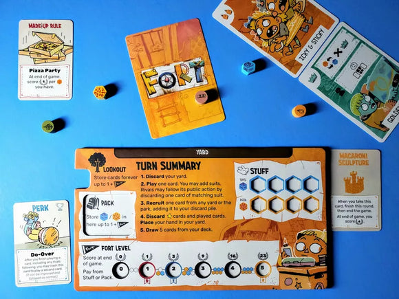 Fort Gameplay Setup with Rule Cards, Perk Card, Kid Cards, Yard and Turn Summary Player Board, with Wooden Tokens Scattered Across a Face Down Card which reads FORT On the back