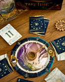 Decorative cards with starry design on a wooden surface, featuring the game pieces found in the box for 'Take Time'.