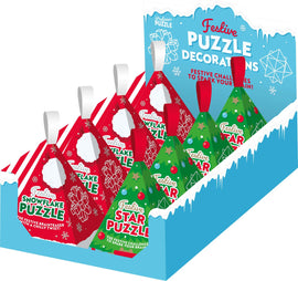 A display of festive puzzle ornaments featuring two colorful designs: a snowflake-shaped red puzzle and a star-shaped green puzzle. Each puzzle has a decorative festive theme with playful graphics and a loop for hanging. The snowy background adds a seasonal touch.