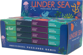 Display of the Under the Sea Puzzle by Project Genius, featuring various colorful puzzle boxes arranged in a block. The boxes indicate different difficulty levels: Easy, Medium, and Hard. Illustrations include vibrant sea creatures like jellyfish and sea turtles, surrounded by underwater plants and a large title label at the back.