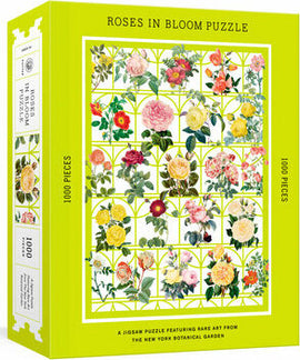 Roses in Bloom Puzzle by Potter Puzzles featuring a vibrant design of various roses and floral illustrations set against a bright green background. The box showcases the title, piece count of 1000 pieces, and art sourced from the New York Botanical Garden.