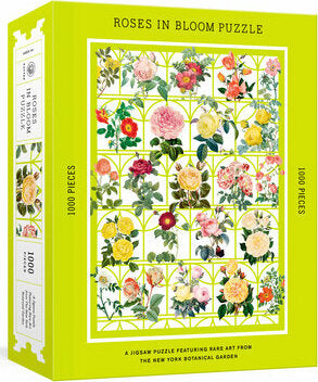 Roses in Bloom Puzzle by Potter Puzzles featuring a vibrant design of various roses and floral illustrations set against a bright green background. The box showcases the title, piece count of 1000 pieces, and art sourced from the New York Botanical Garden.