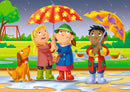 A vibrant jigsaw puzzle illustration featuring three children standing together under colorful umbrellas in the rain. They are smiling joyfully, surrounded by a playful dog and ducks in a park setting with trees and a swing in the background.