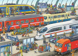 A vibrant illustration of a busy railway station featuring various trains including high-speed and regional trains. The scene is bustling with passengers of all ages, some boarding or disembarking, while others are seen interacting with their luggage or waiting on benches. Colorful characters populate the platform, surrounded by signs, schedules, and transport details. The artwork captures the lively atmosphere of train travel.