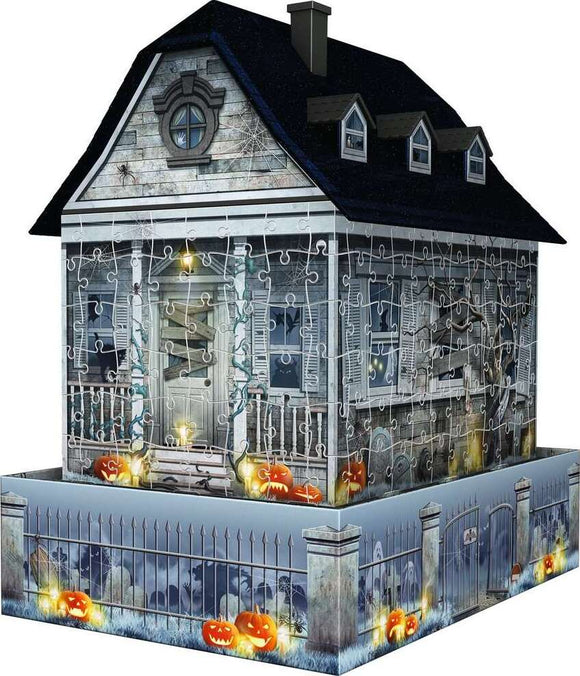 3D Haunted House Night Edition jigsaw puzzle by Ravensburger, featuring a spooky house illuminated with carved pumpkins and webs. The puzzle forms a three-dimensional haunted house with intricate details and a ghostly background, perfect for Halloween enthusiasts.