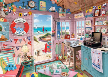 The Beach Hut 1000 pc Puzzle by Ravensburger features a charming beach hut interior filled with nautical decor, a cozy kitchen, and a view of the beach. The puzzle showcases vibrant colors, intricate details, and playful elements like beach toys, a lifebuoy, and themed wall art, perfect for puzzle enthusiasts.