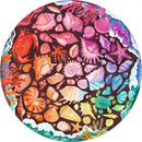A vibrant 500-piece round jigsaw puzzle featuring an assortment of colorful seashells, starfish, and marine life set against a dark background. The artwork showcases various shell shapes and textures, including a crab and a turtle, surrounded by ocean waves and colorful corals, creating a beautiful marine scene ideal for puzzle enthusiasts.