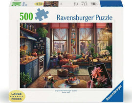 Ravensburger Cozy BoHo Studio 500 piece jigsaw puzzle featuring a beautifully detailed living room scene adorned with plants, a cozy couch, and a vibrant city view through large windows. Includes large, easy-to-handle pieces, perfect for puzzle enthusiasts.