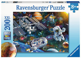 Ravensburger Puzzle featuring a cosmic exploration theme, depicting an astronaut floating in space among planets, stars, and the International Space Station. The box showcases a vibrant and colorful galaxy background filled with swirling cosmic elements, perfect for puzzle enthusiasts aged 8 and up.
