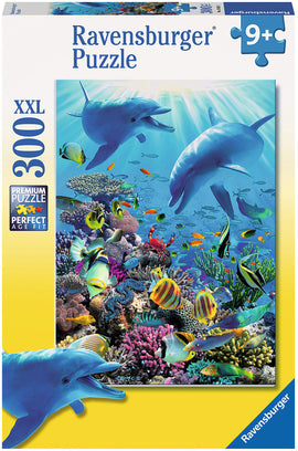 The Ravensburger Underwater Adventure jigsaw puzzle features a vibrant underwater scene with dolphins, colorful fish, and coral reefs. This 300-piece puzzle is designed for ages 9 and up, showcasing detailed marine life in a bright, engaging illustration. The box highlights the premium quality and XXL size of the puzzle pieces, making assembly enjoyable for puzzle enthusiasts.