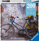 A Ravensburger Jigsaw Puzzle titled 'Puzzle Moments: Bicycle'. It features a vintage bicycle parked against a weathered wall adorned with flowers. The puzzle consists of 200 pieces, making it ideal for relaxation and leisure time. The packaging displays a blue header with the number 200 prominently featured.